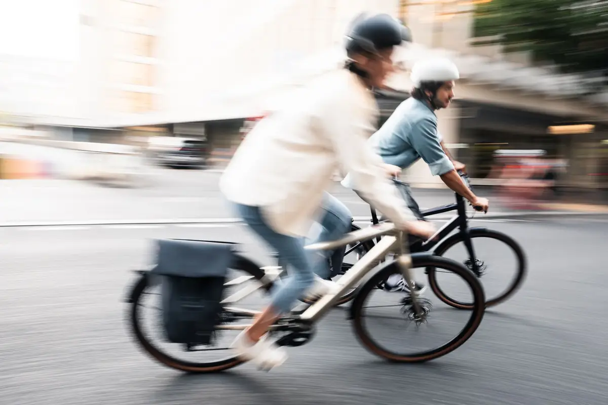 Zwei Fahrer auf BIXS E-Bikes in der Stadt in Bewegungsunschärfe