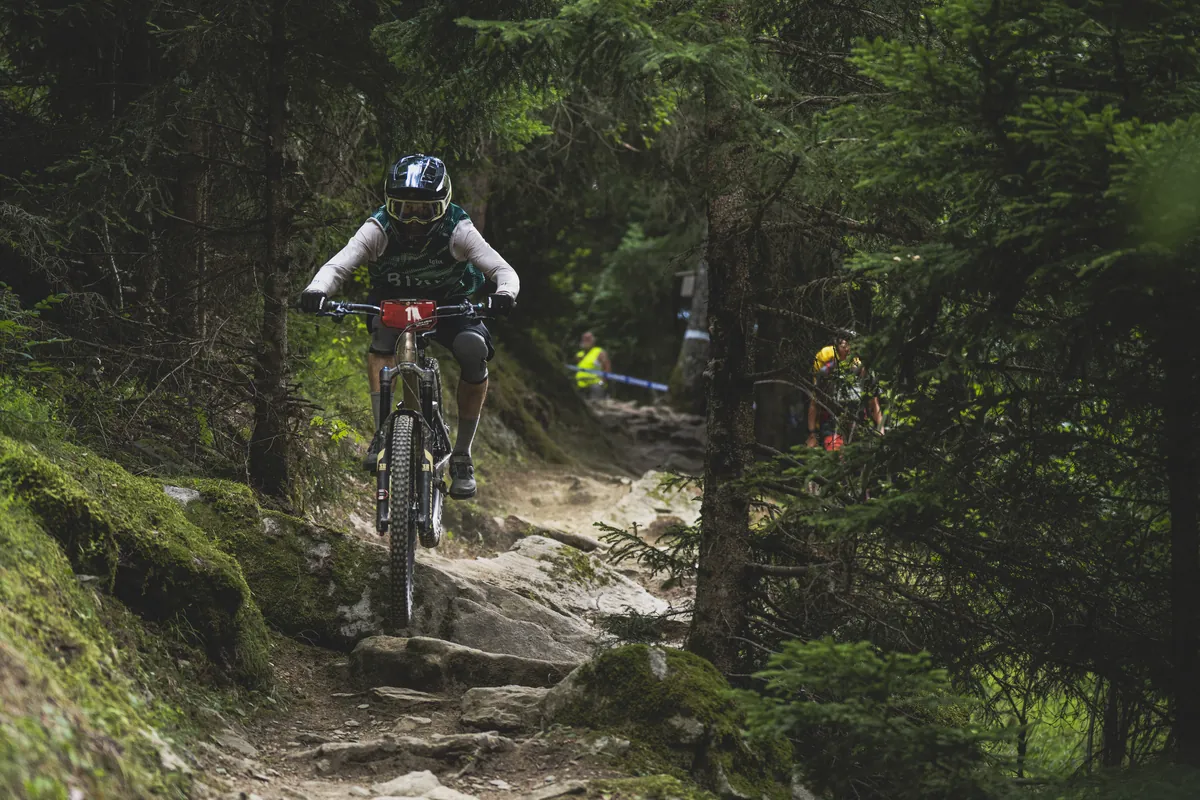 BIXS Enduro-Fahrer fährt durch felsigen Waldtrail beim Rennen in der Aletsch Arena