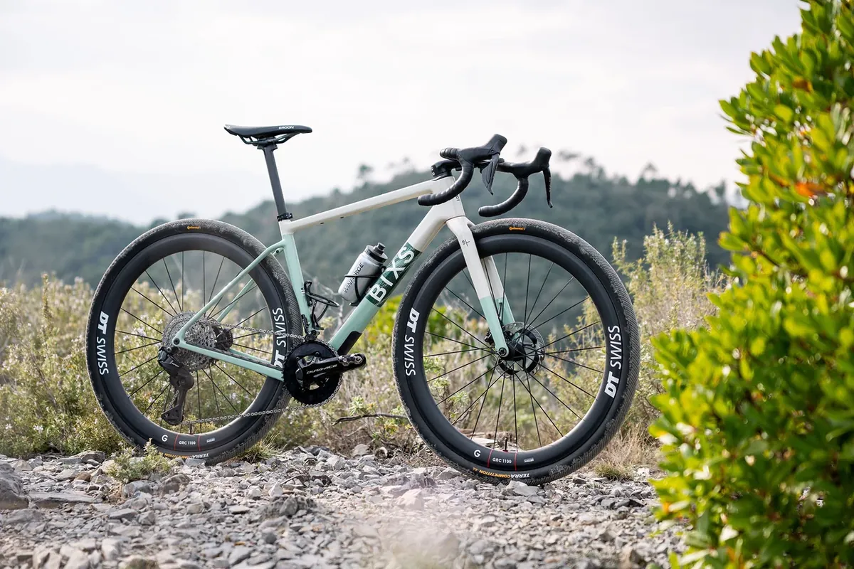 BIXS Team-Gravelbike in Mint-Weiss, Seitenansicht auf Schotterweg