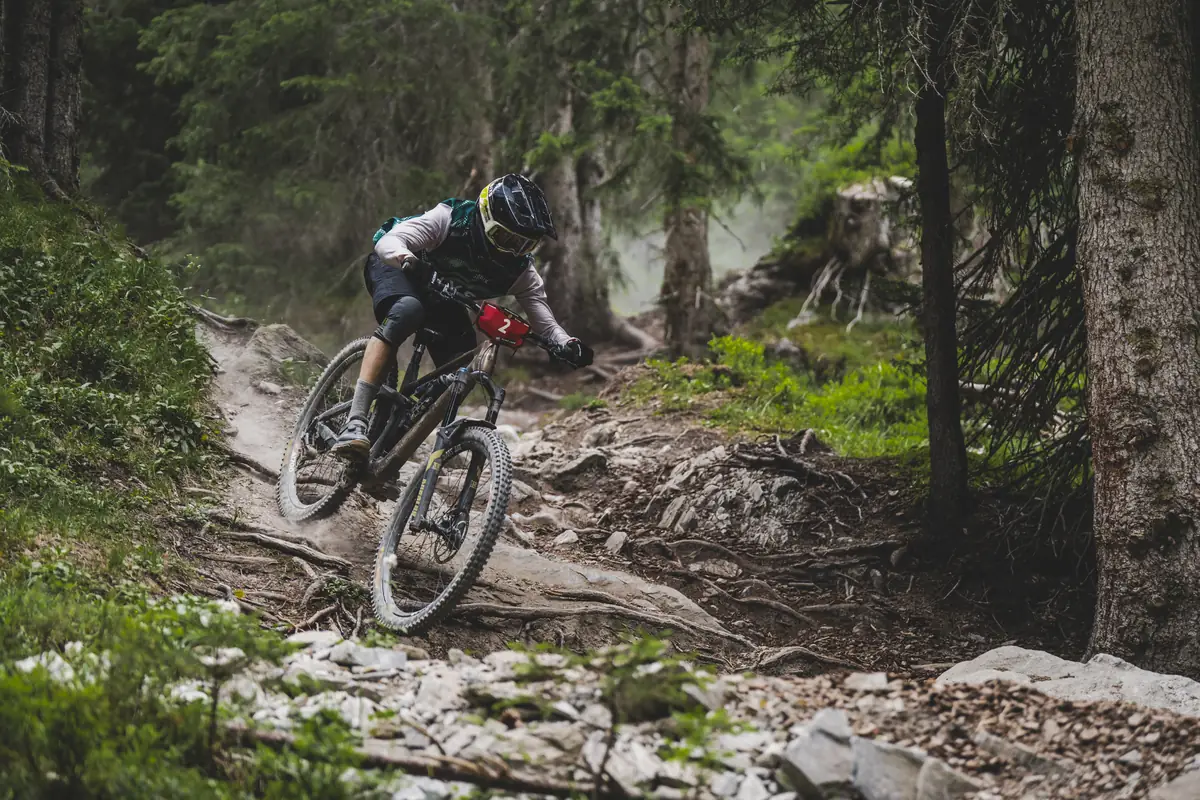 BIXS Race Team Fahrer bei der Abfahrt über einen wurzeligen Waldtrail bei den Swiss Enduro Series