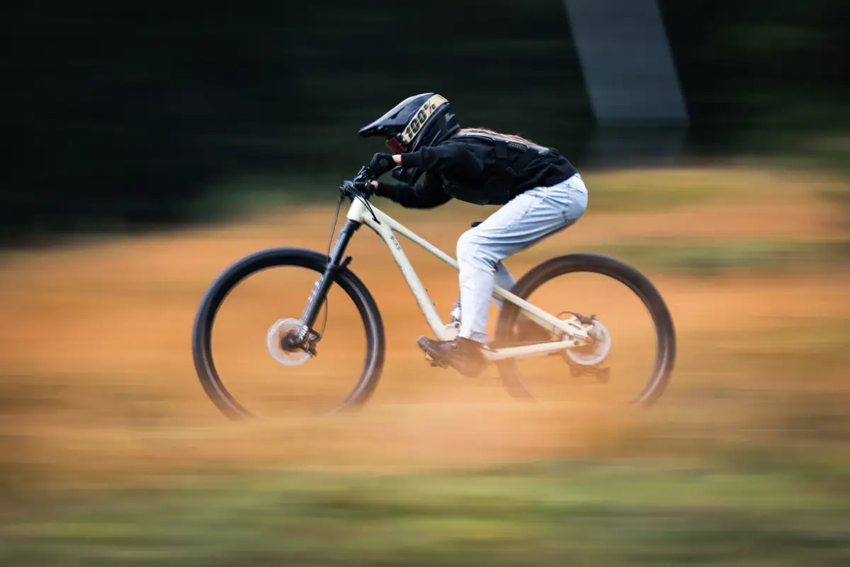 Kind der BIXS Traction Crew springt mit dem Mountainbike, Bewegungsunschärfe