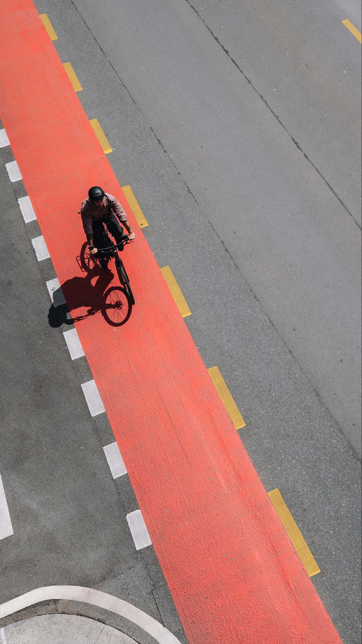 Radfahrer mit BIXS Urban Bike aus der Vogelperspektive auf rotem Velostreifen in der Stadt