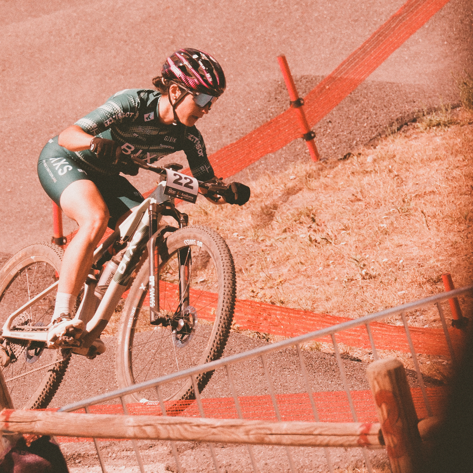 BIXS Rennfahrerin mit Startnummer 22 fährt eine Schotterkurve auf der Cross-Country-Strecke hinunter