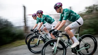 BIXS Race Team Fahrer in grünen Trikots auf Gravelbikes mit starker Bewegungsunschärfe