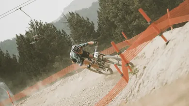 Rennfahrer mit Startnummer 22 in Schräglage auf BIXS Pace Cross-Country-Bike an Streckenbegrenzung