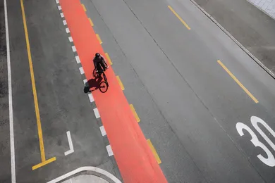 Radfahrer mit BIXS Urban Bike aus der Vogelperspektive auf rotem Velostreifen in der Stadt