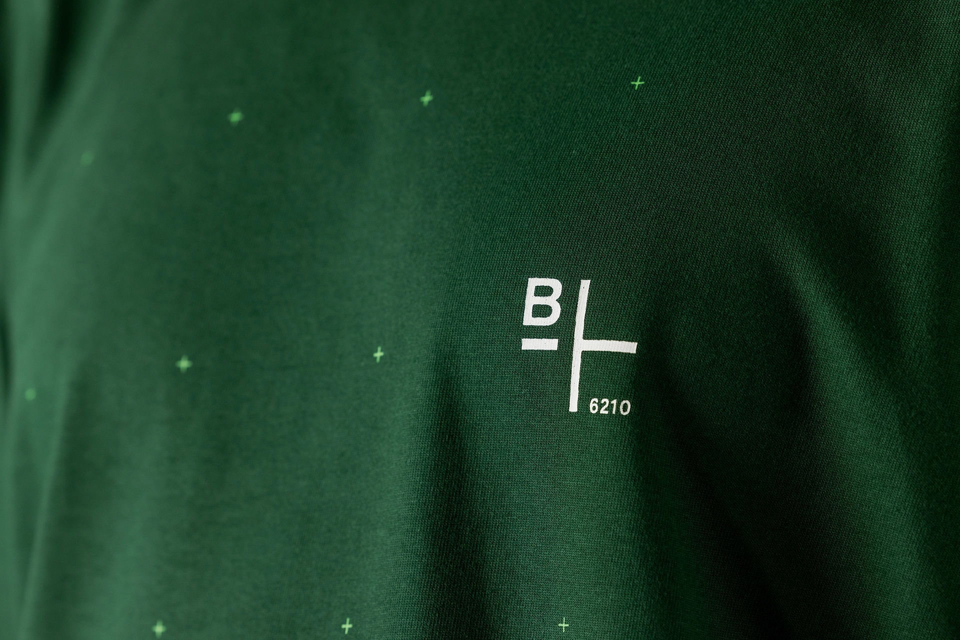Nahaufnahme des BIXS Logos auf grünem Crew-Wear-Stoff