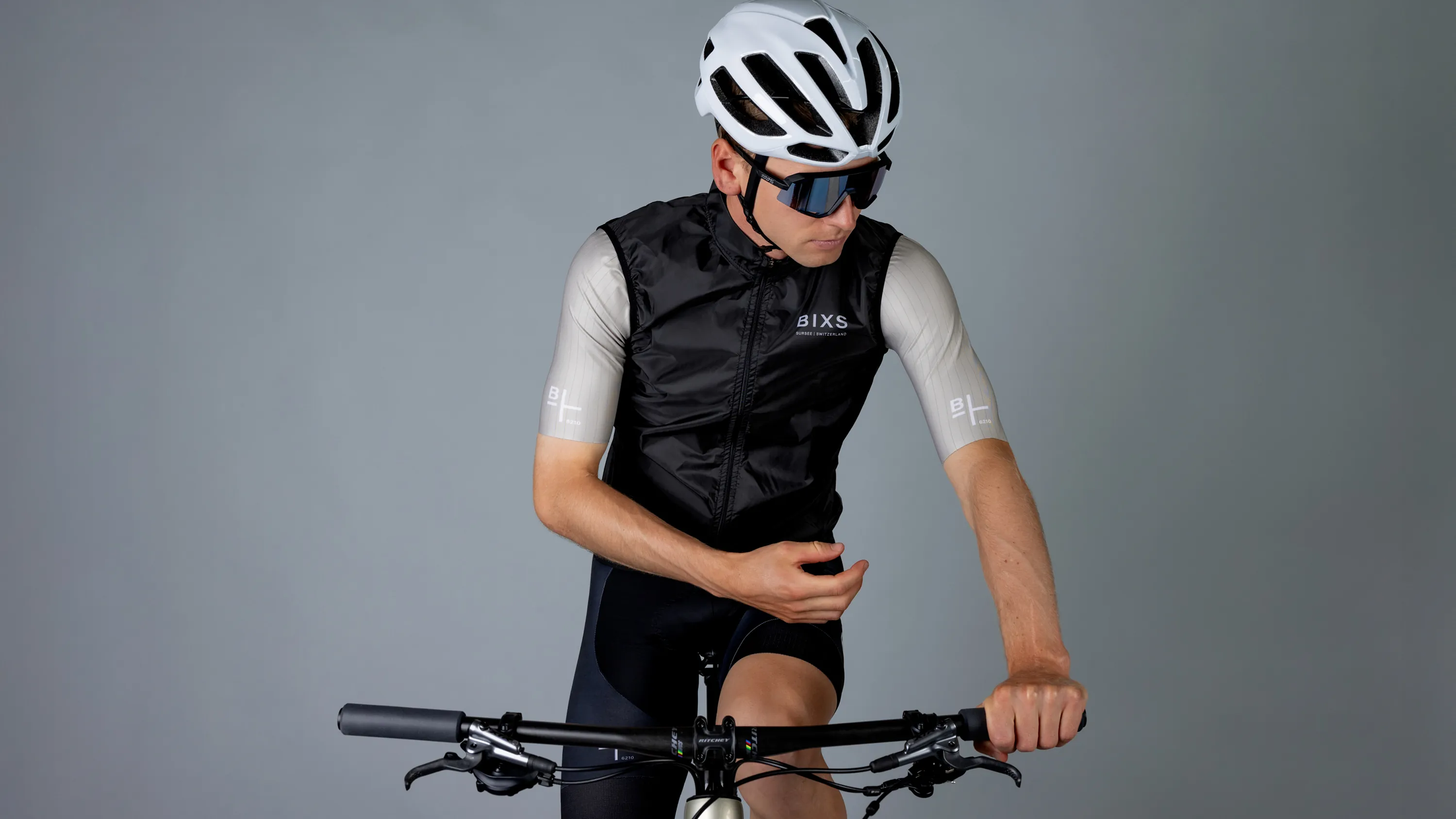 Fahrer in schwarzer BIXS Weste und Renttrikot mit Helm und Sonnenbrille auf Bike