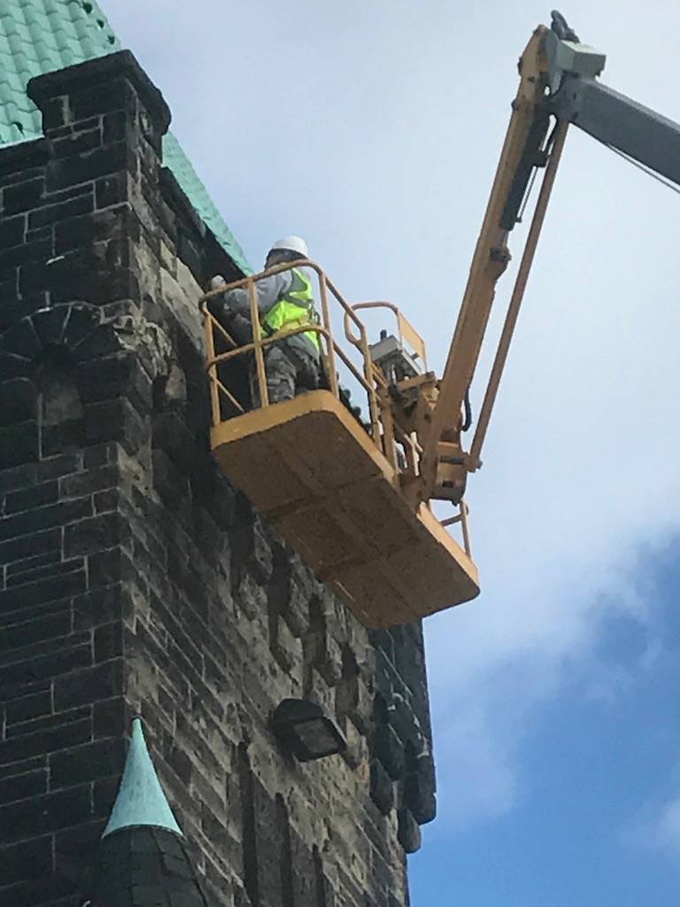 tuckpointing brick replacement construction workers on crane above all masonry and construction
