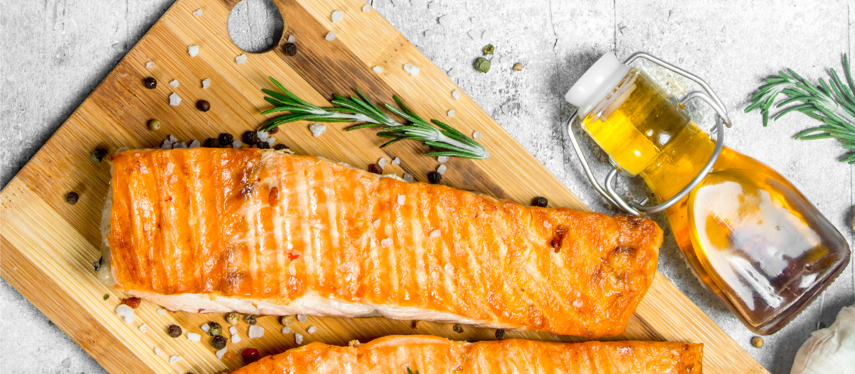 Von oben: Fisch auf Holzteller mit Gewürzen angerichtet.