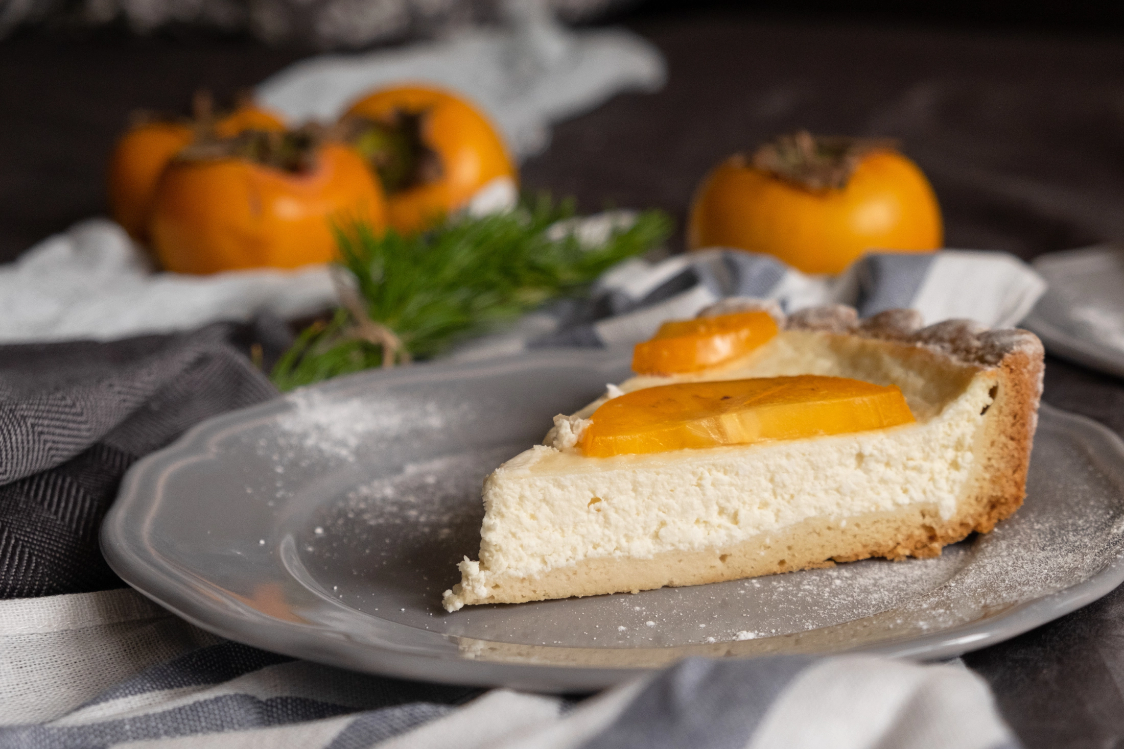 Ein Stück Kaki-Mandel Tarte auf Kuchenteller