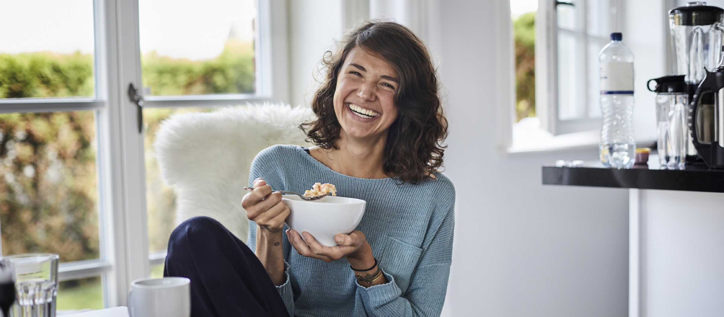 Glückliche Frau frühstückt.