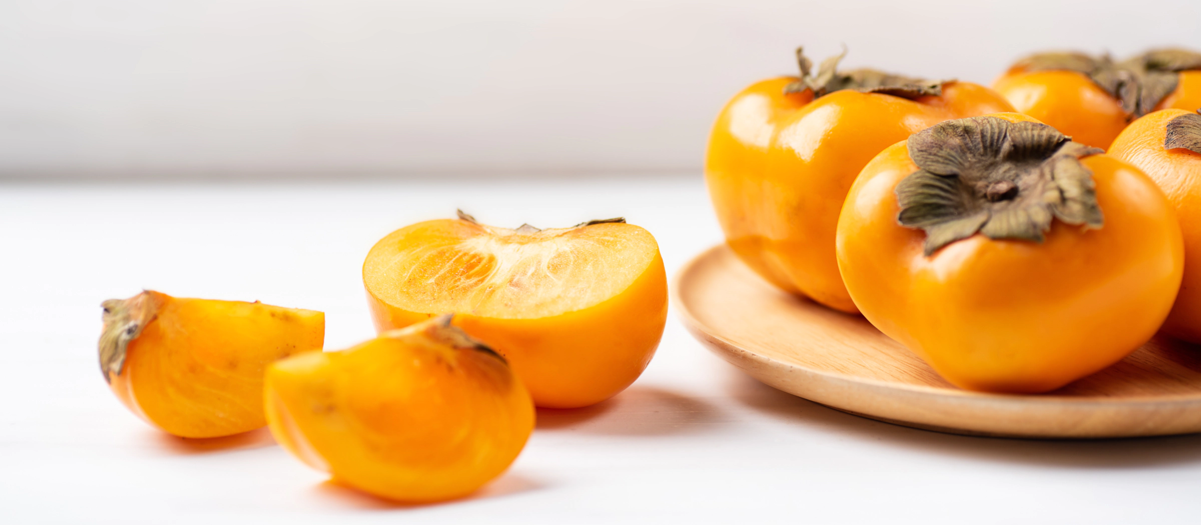 Kakis auf einem Teller.