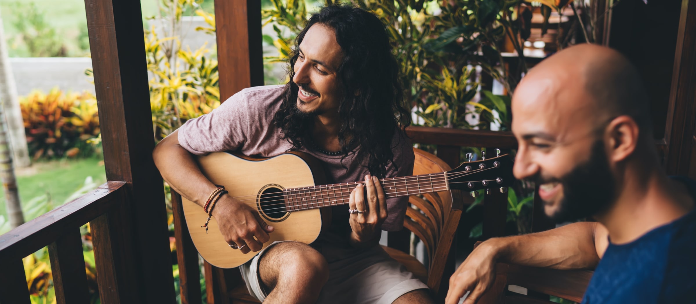 Freunde spielen auf der Terrasse Gitarre.
