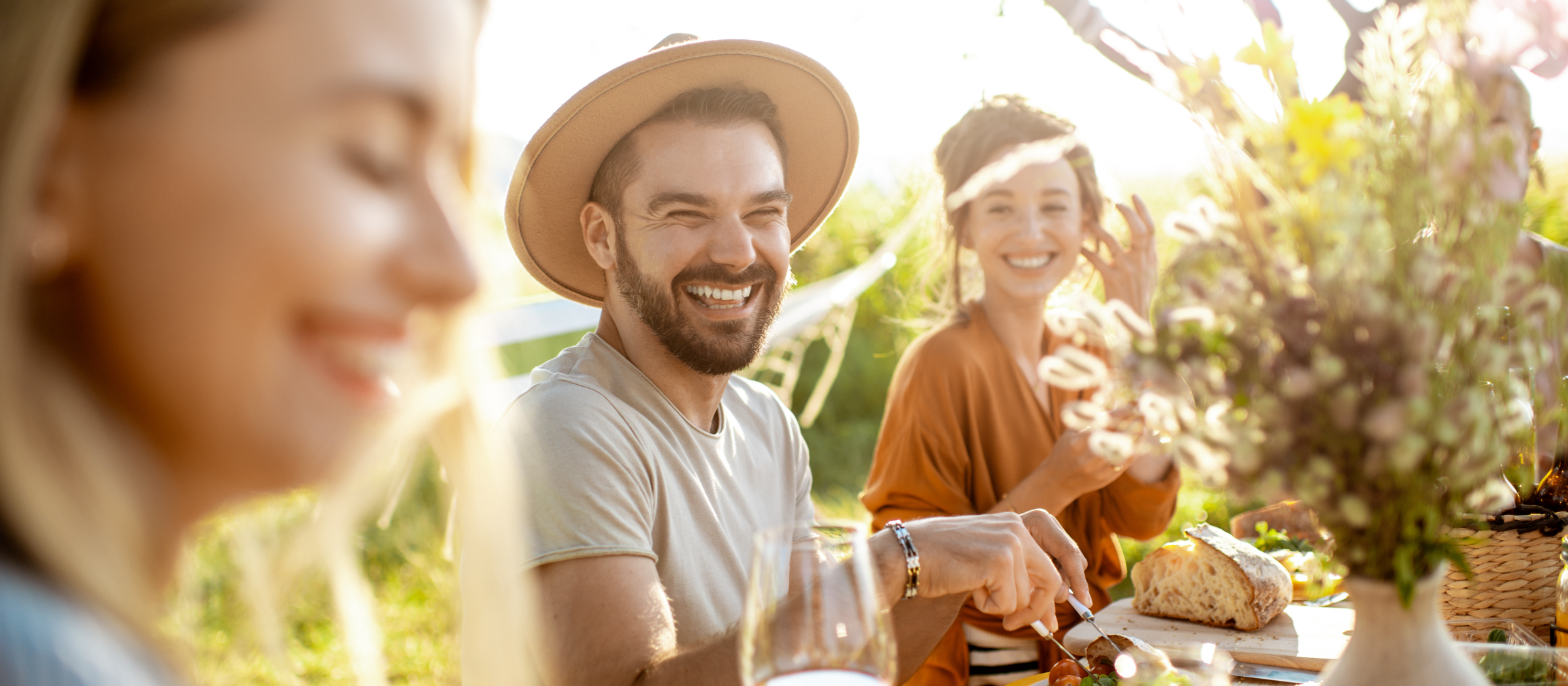 Menschen sitzen zusammen in der Natur und essen.