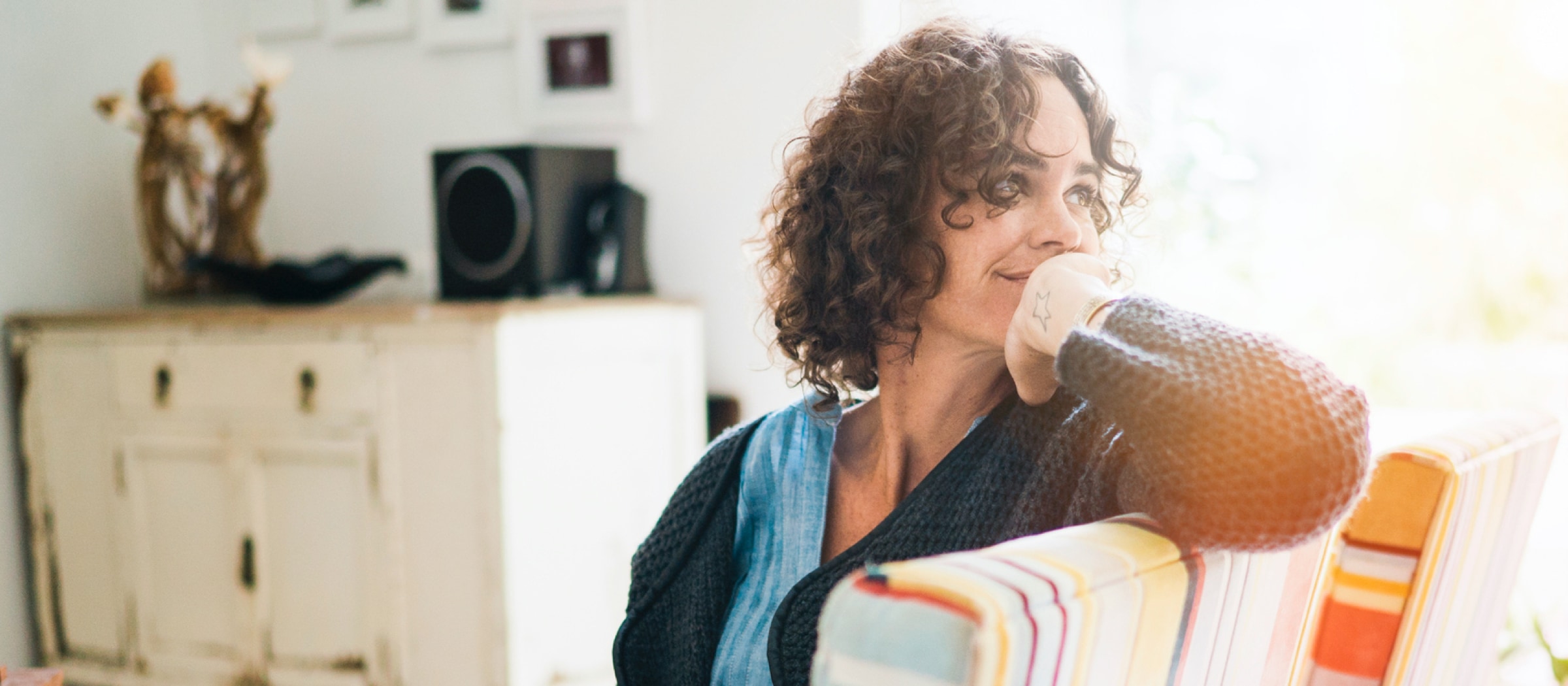 Frau sitzt auf einem Stuhl und lächelt.