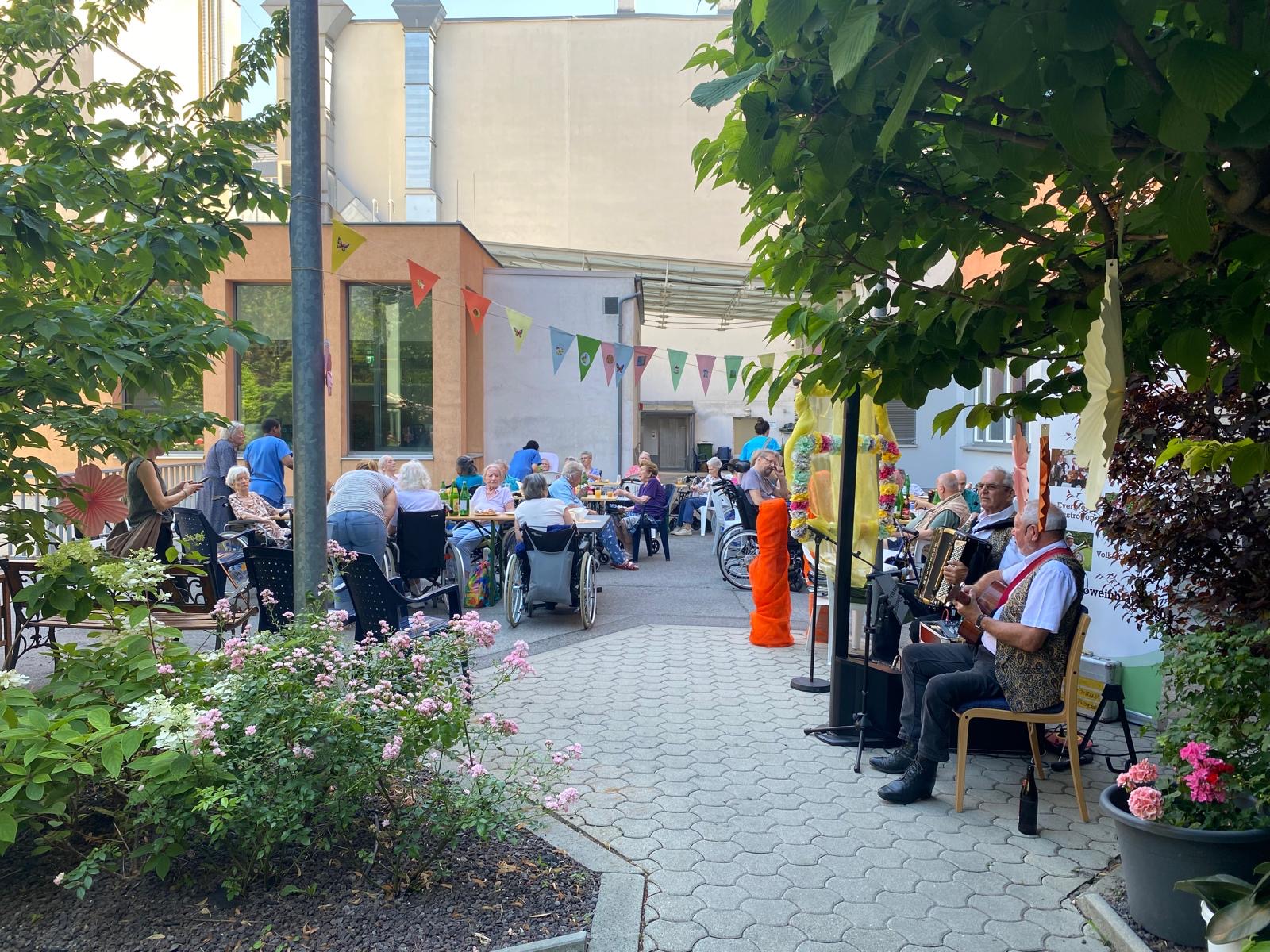 Bewohner*innen-Sommerfest mit bunter Dekoration im Garten
