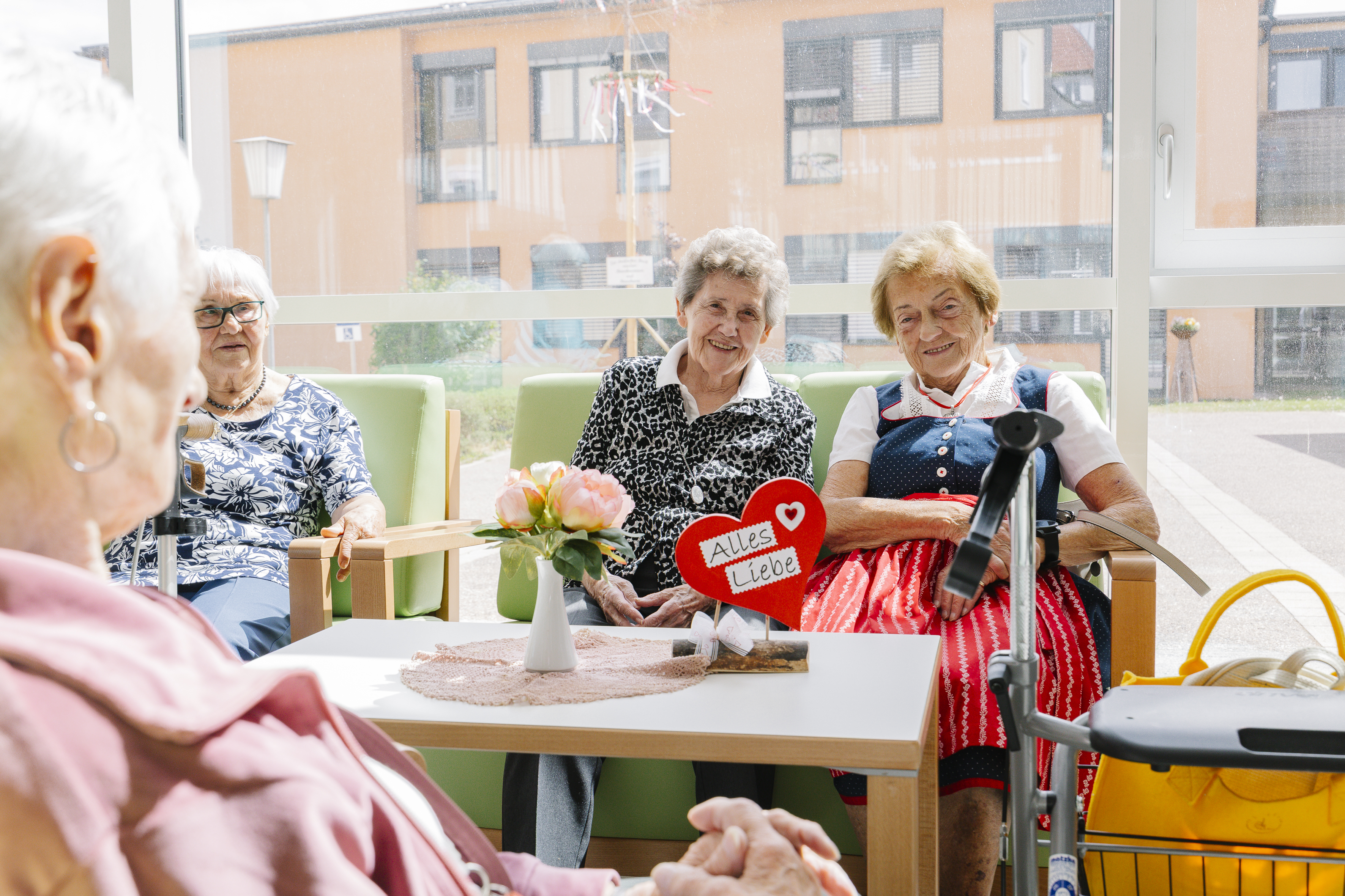 Einige Bewohnerinnen sitzen gemütlich zusammen am Stammtisch