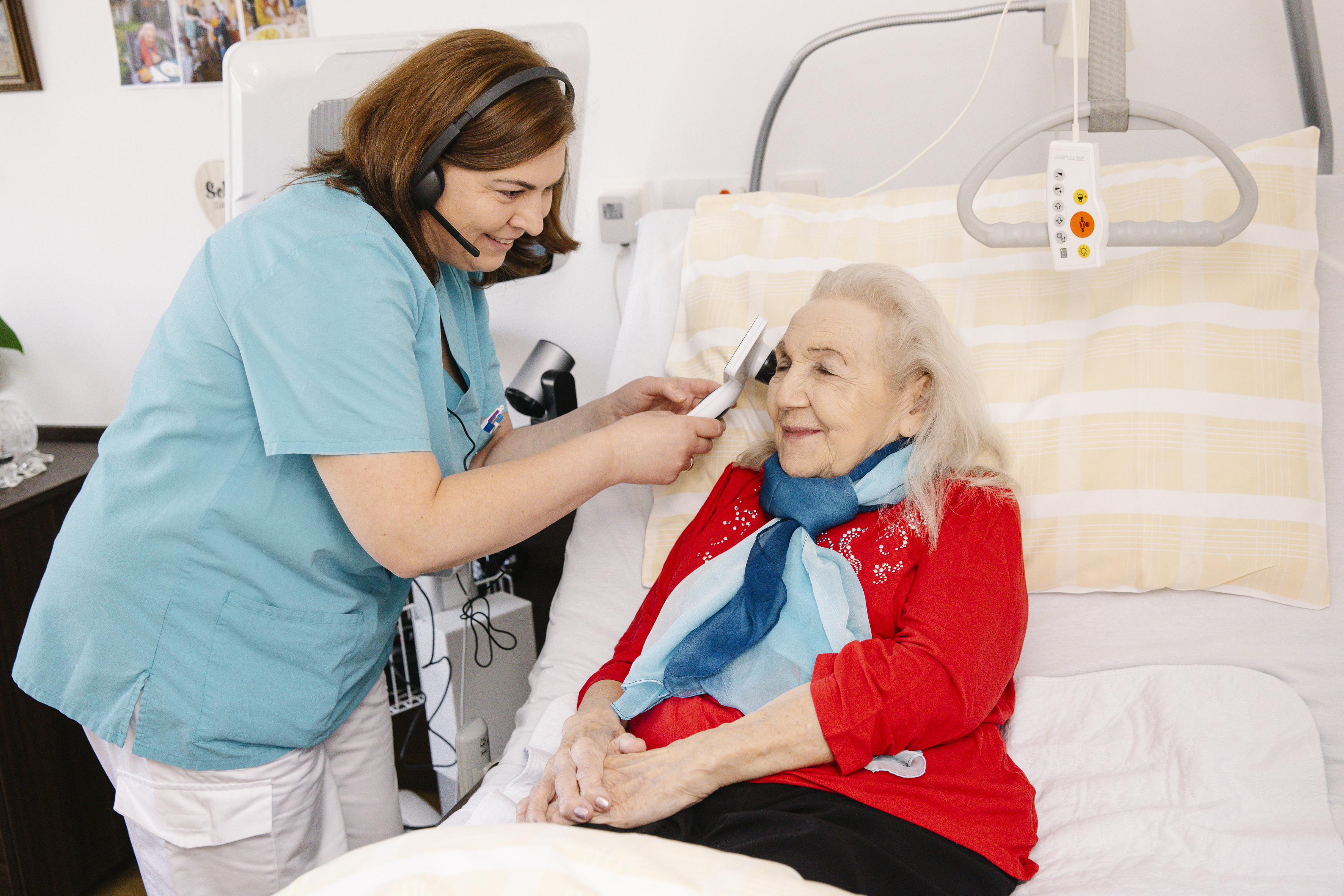 Eine Pflegekraft untersucht das Ohr einer Bewohnerin.