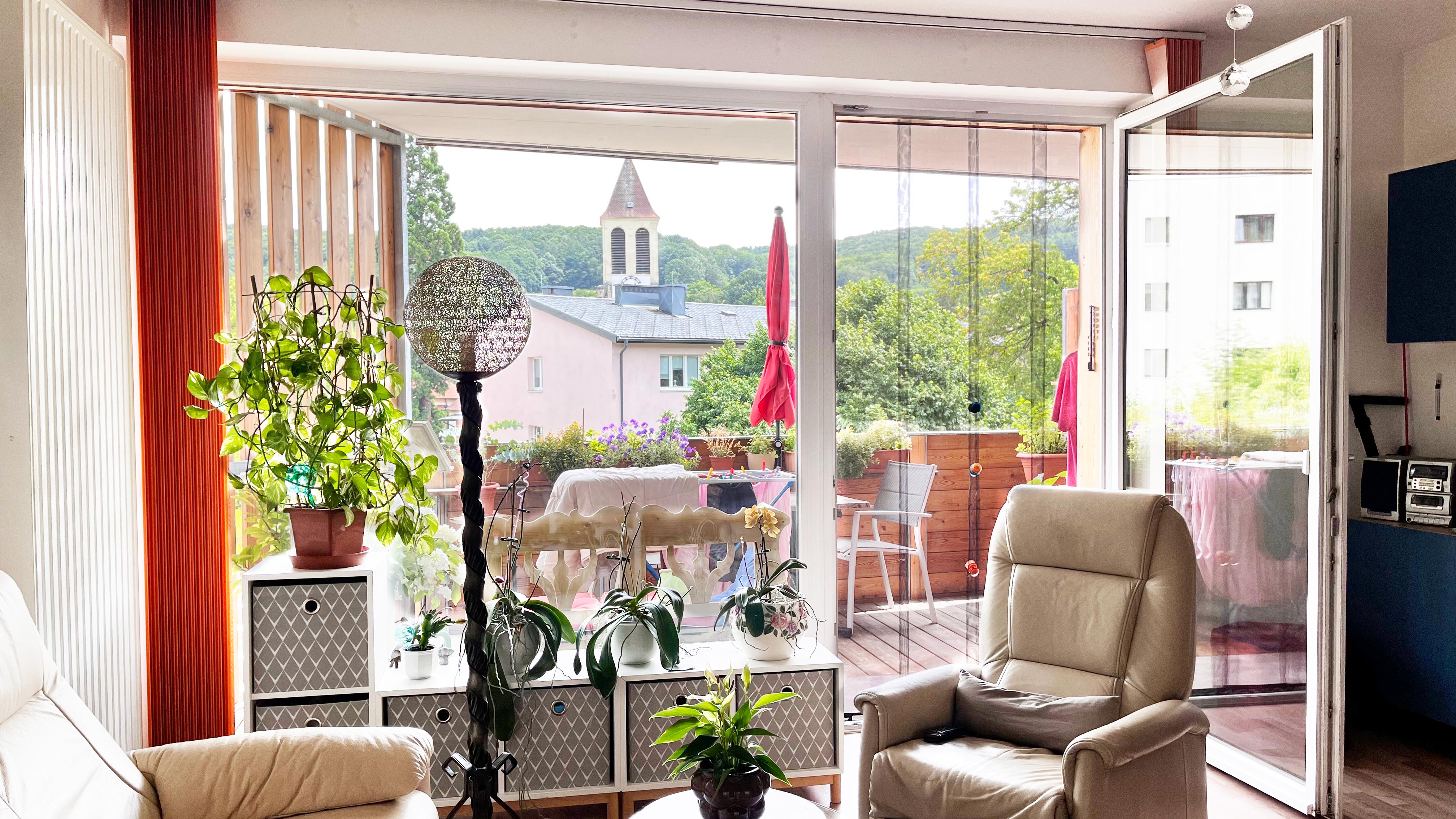 Gemütliches Wohnzimmer mit Ausblick ins Grüne vom Balkonfenster