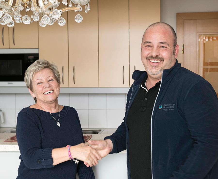 Eine ältere Dame bedankt sich beim Sozialbetreuer für die Hilfe in ihrer Wohnung