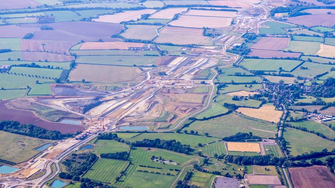 Aerial view of patchwork farmland and hedgerows with a wide construction corridor