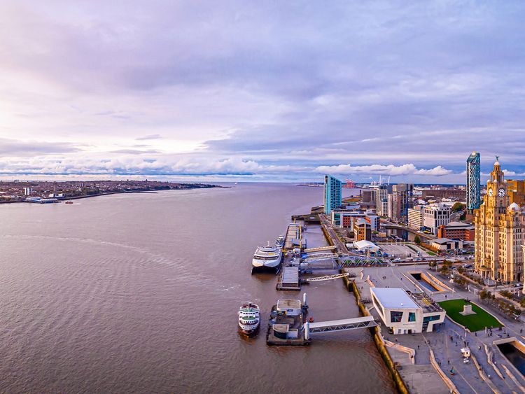 Aerial view of a Liverpool waterfront at dusk, featuring modern and historic buildings.