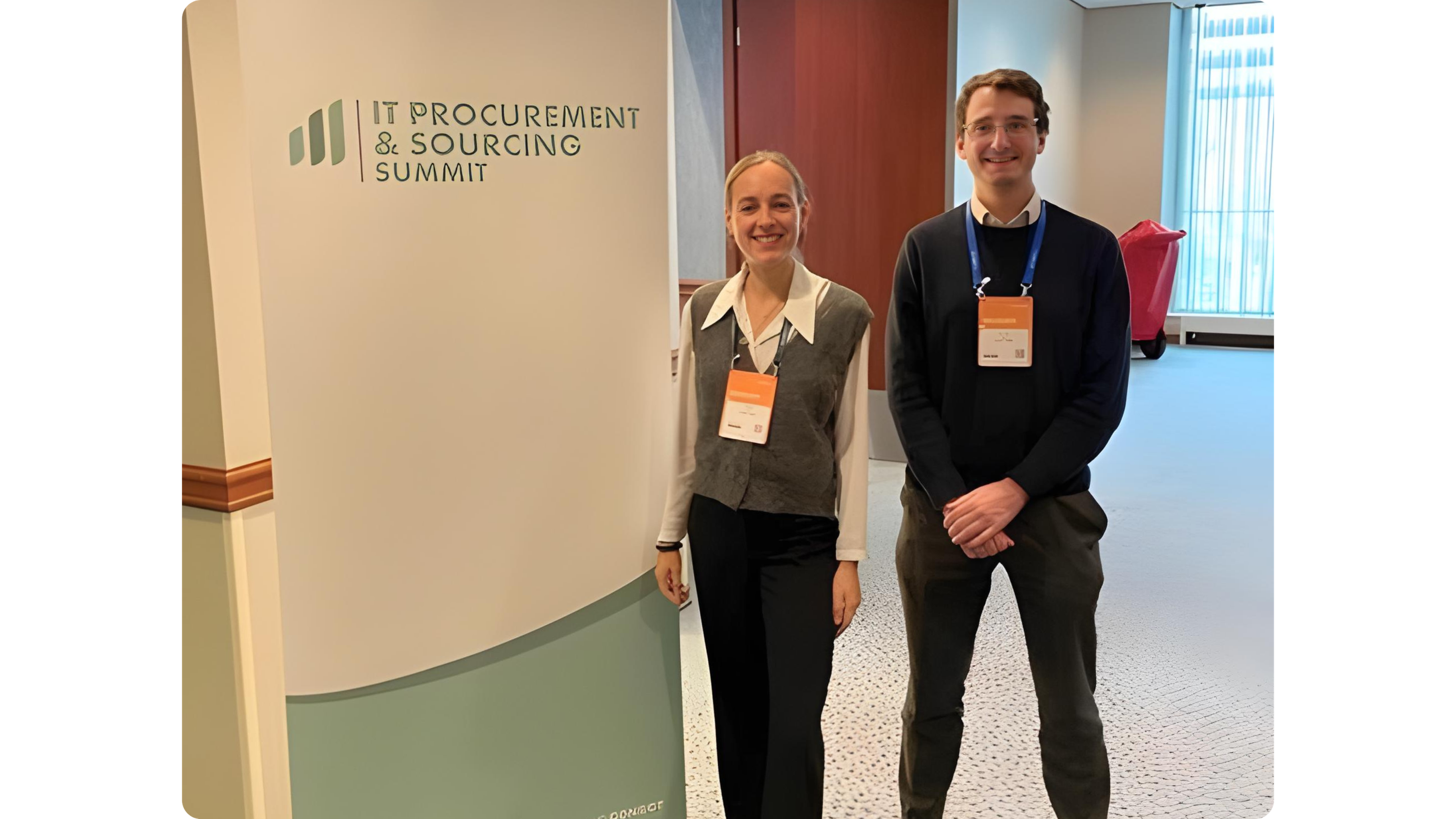 Celina Le Bec and Romain Lopez standing next to an IT Procurement and Sourcing Summit kakemono