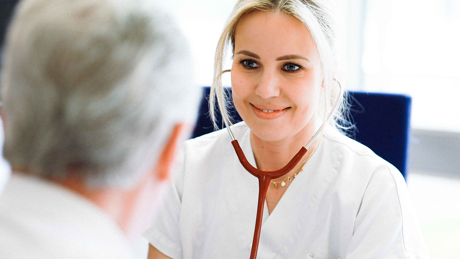 Pflegefachkraft hört mit dem Stethoskop einen Patienten ab.