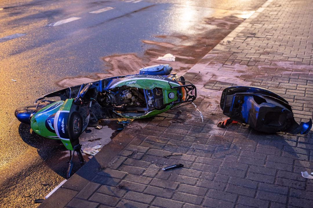 A scooter on the side of the road following an accident