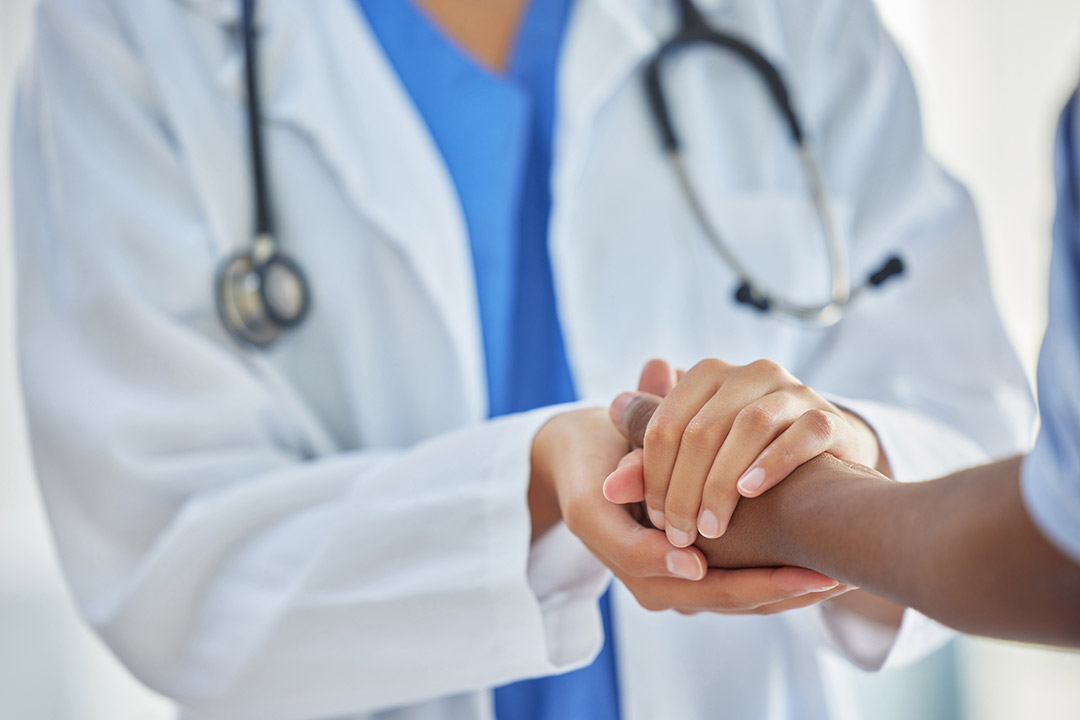 A nurse holding a patients' hands