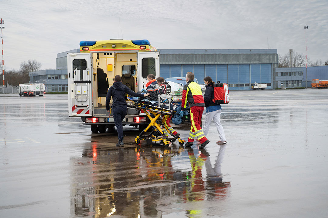 A patient on a stretcher being placed in a ground ambulance