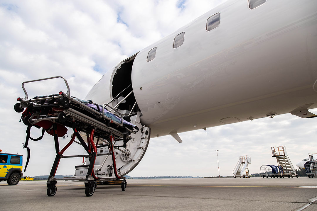 A patient on a stretcher being placed on an aircraft