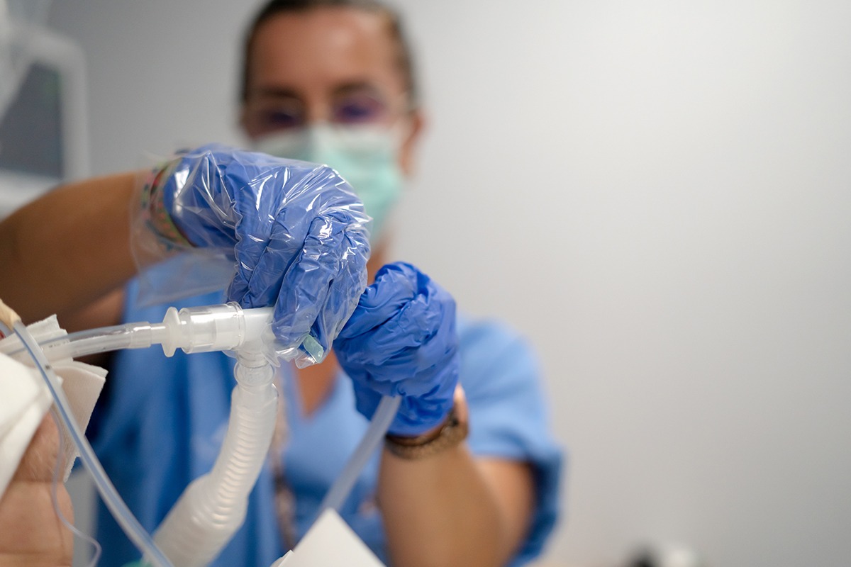 A healthcare worker setting a ventilator