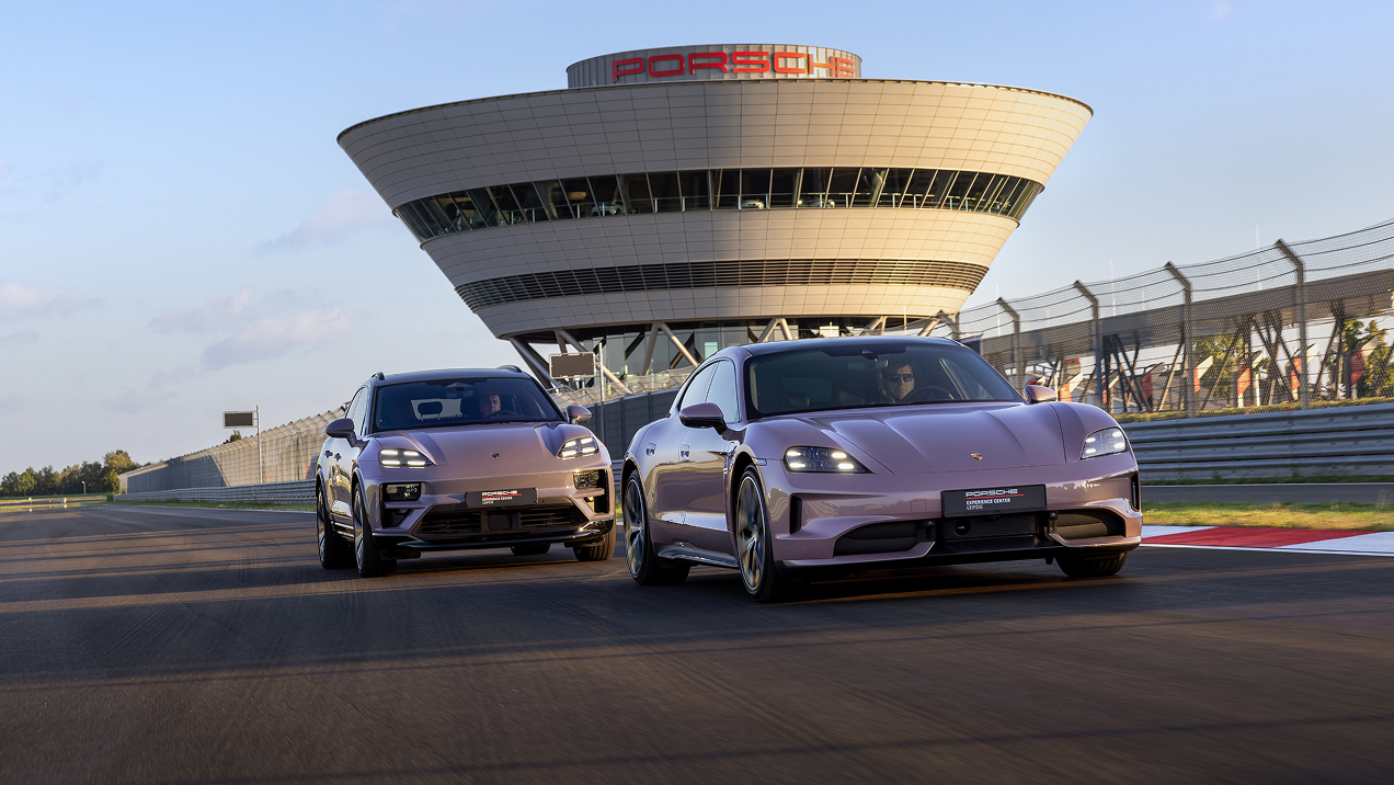 Ein Porsche Taycan fährt vor einem Porsche Macan auf einer Rennstrecke beim Porsche Experience Center Leipzig.