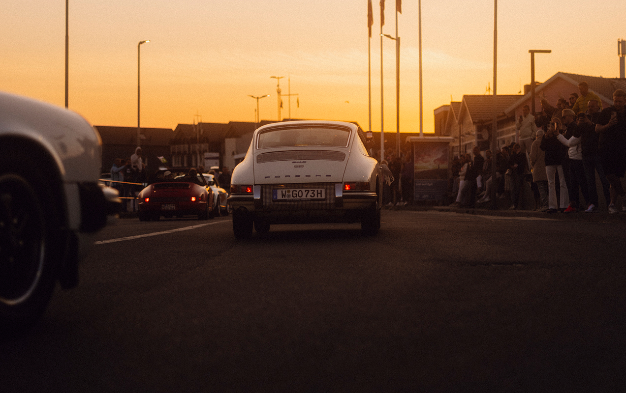 Ein klassischer Porsche 911 fährt in den Sonnenuntergang.