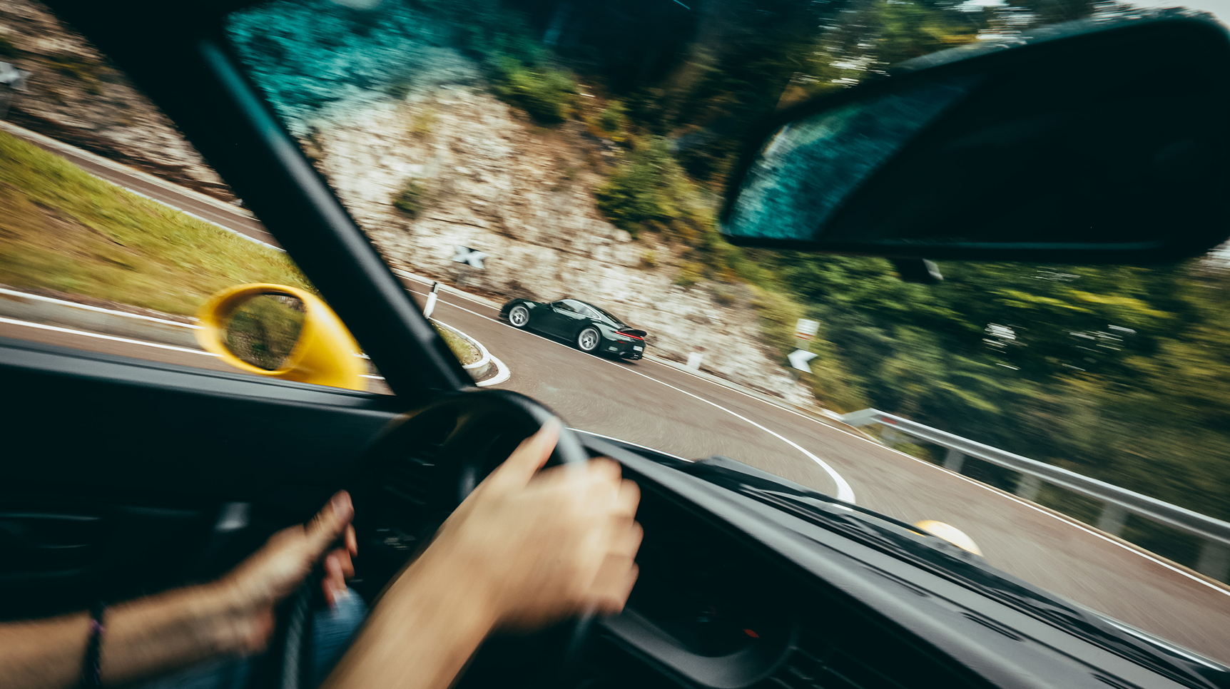 Blick aus dem Cockpit eines Porsche der um eine enge Kurve fährt.