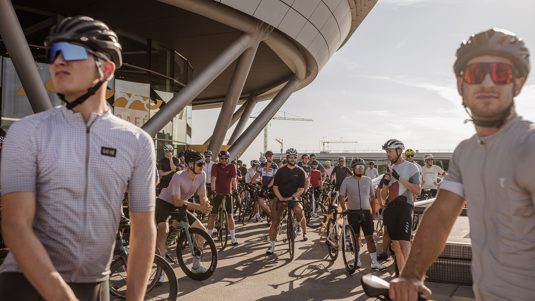 Viele Fahrradfahrer sammeln sich vor dem Porsche Experience Center Leipzig.