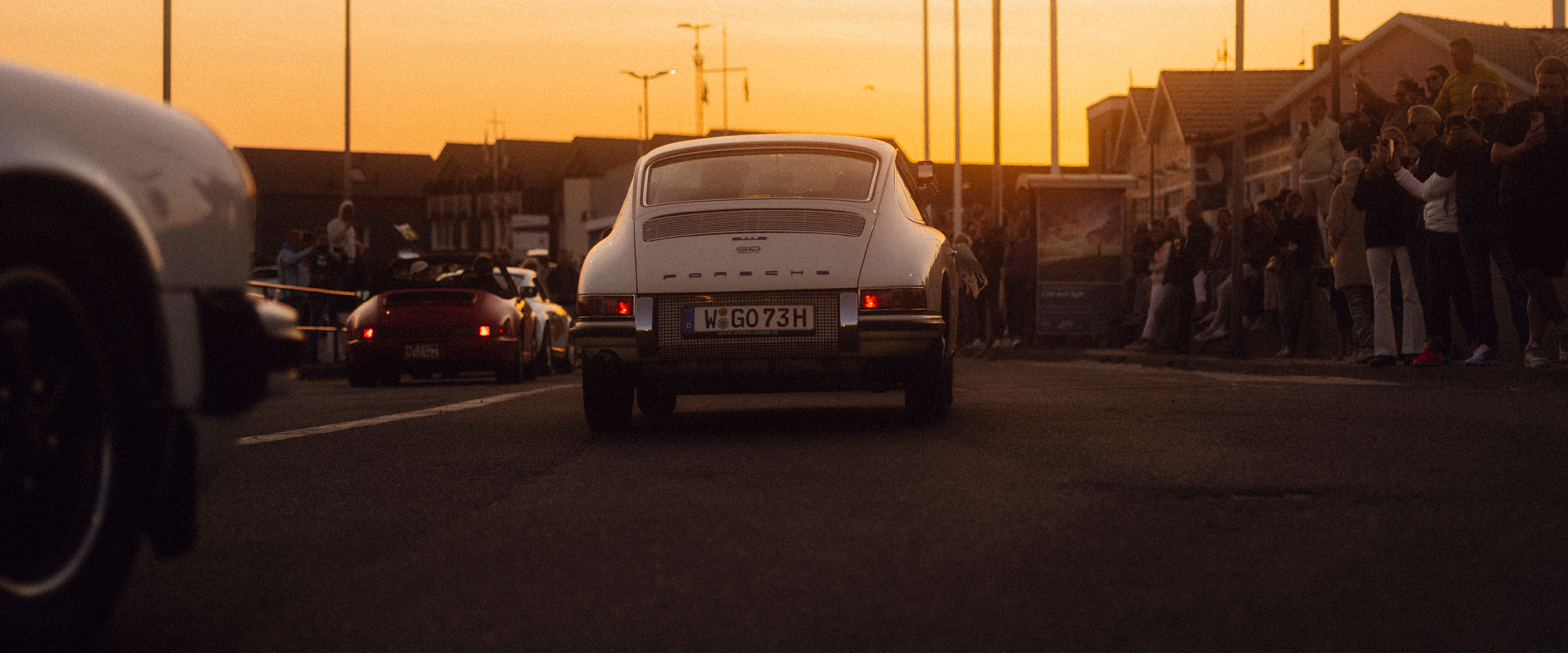 Ein klassischer Porsche 911 fährt in den Sonnenuntergang.