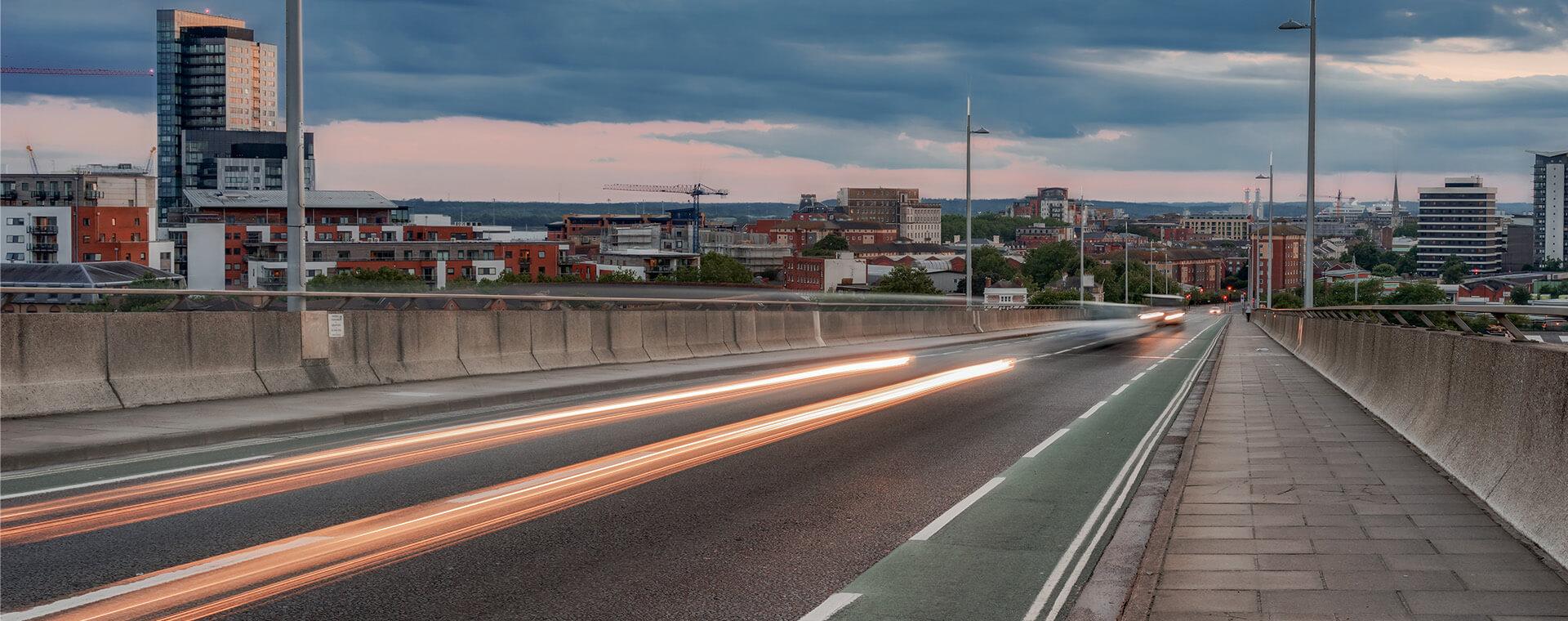A car with a dash effect driving on a road.