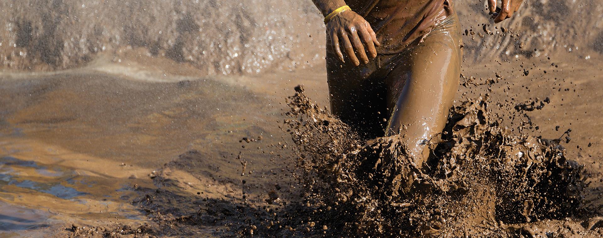 Mud soaked legs of a Tough Mudder participant running