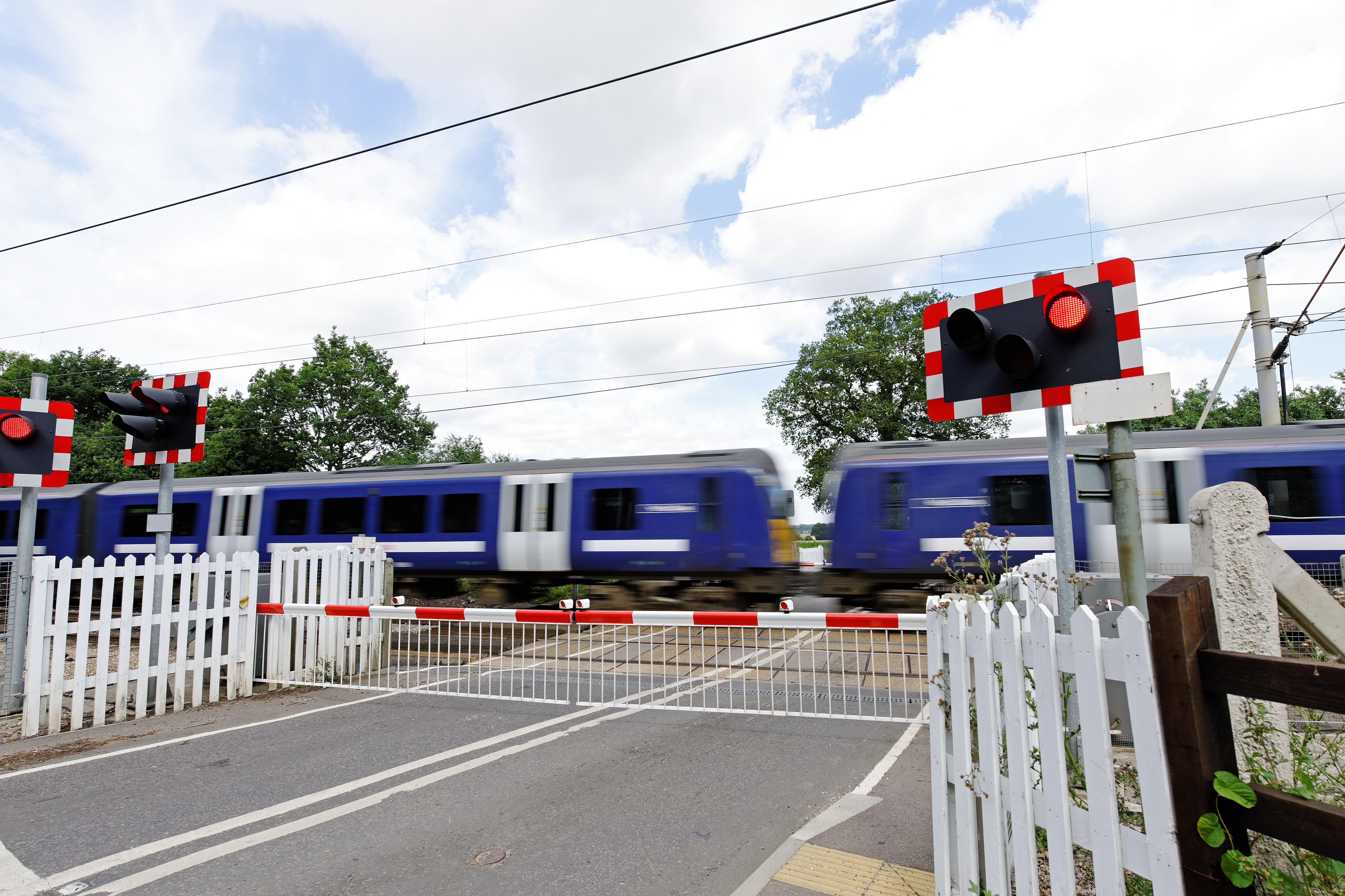 Level crossing with a train passing by.