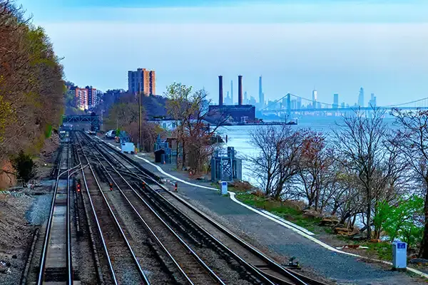 A Railroad headed towards a large city skyline
