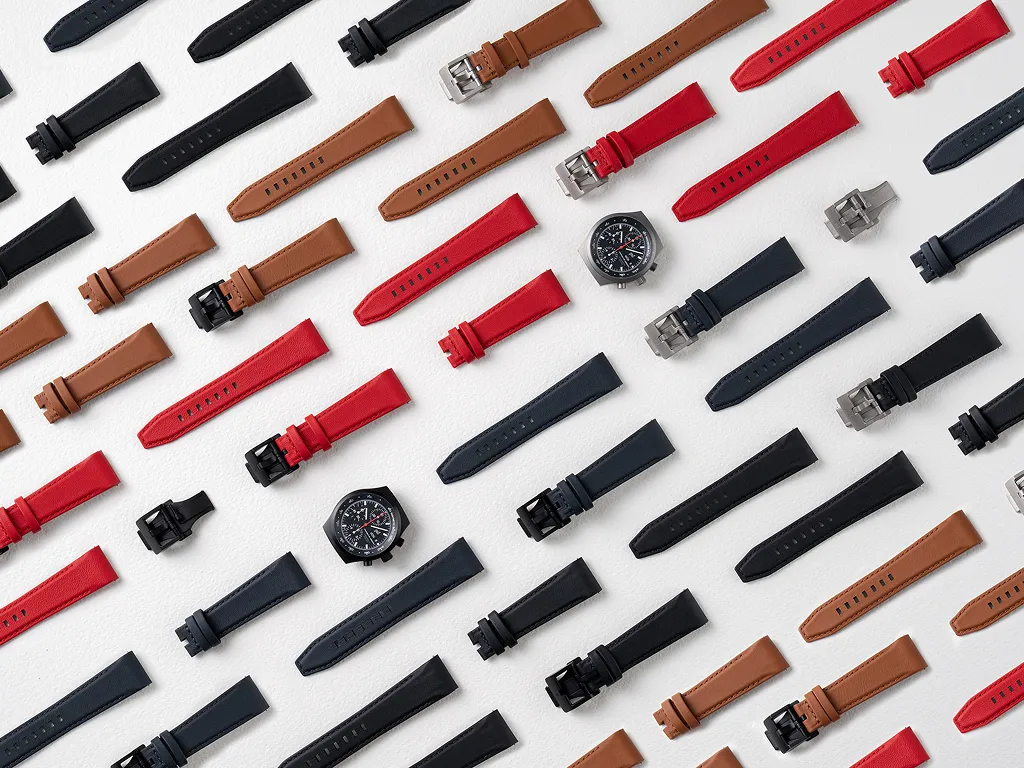 Porsche Design Timepieces leather straps along with two chronographs, arranged neatly on a white background.