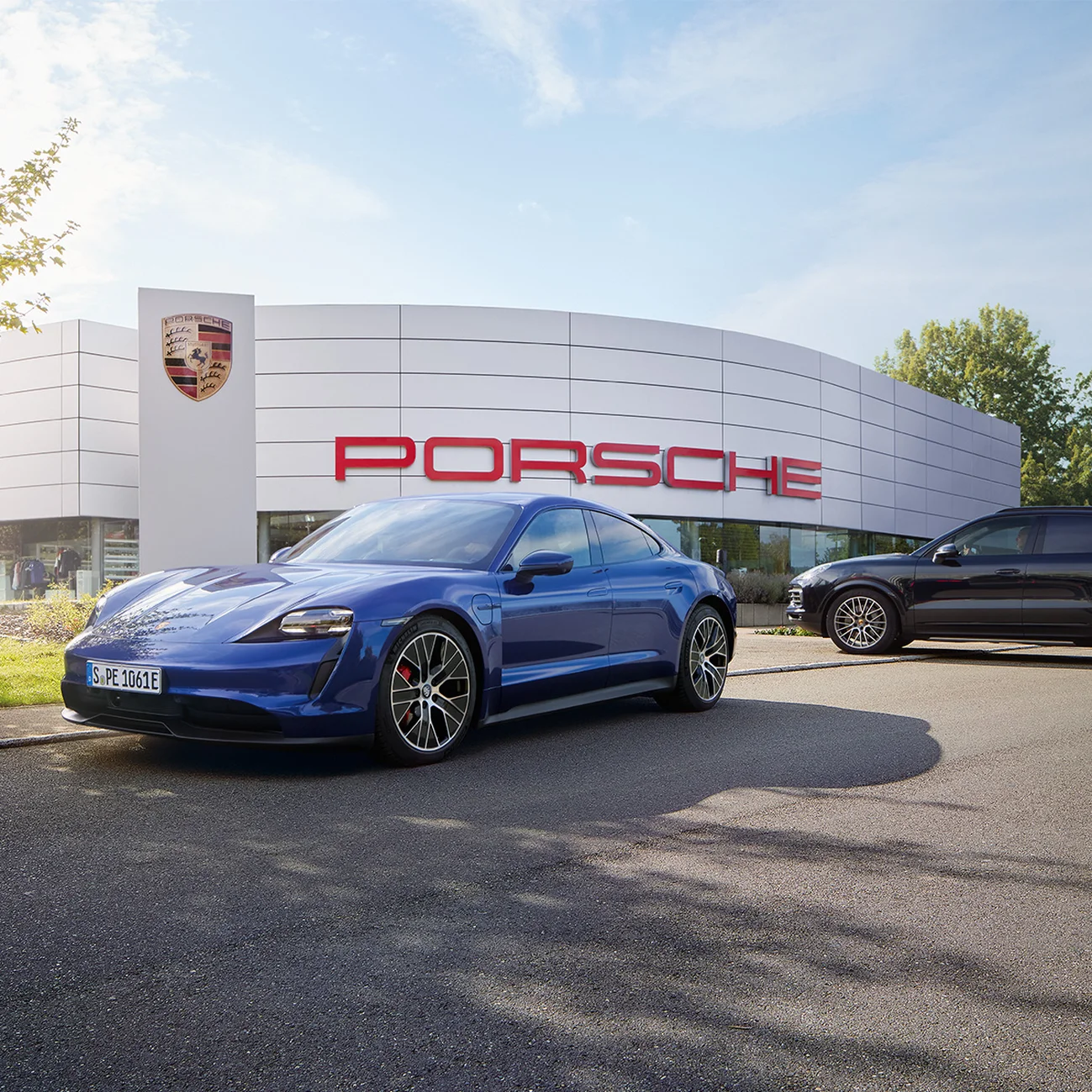 Blue Porsche Taycan outside a Dealership.