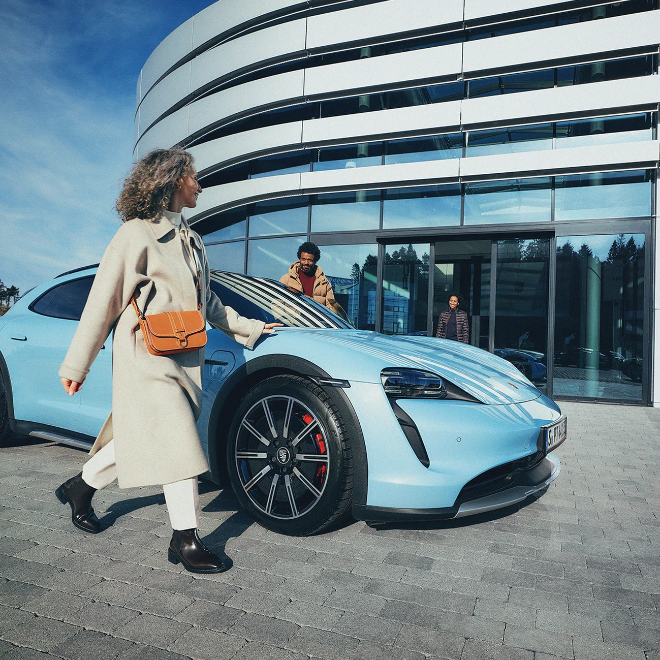 Koppel staat voor een Porsche Centrum met daartussen een Porsche Macan.