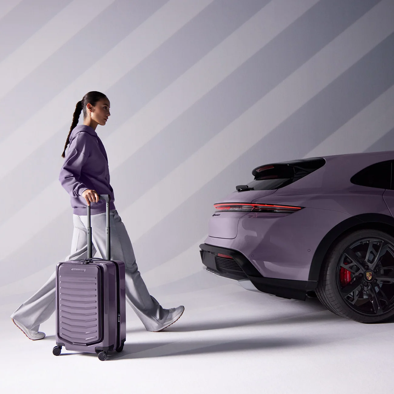 Vrouw met Porsche trolley voor een Porsche Taycan.