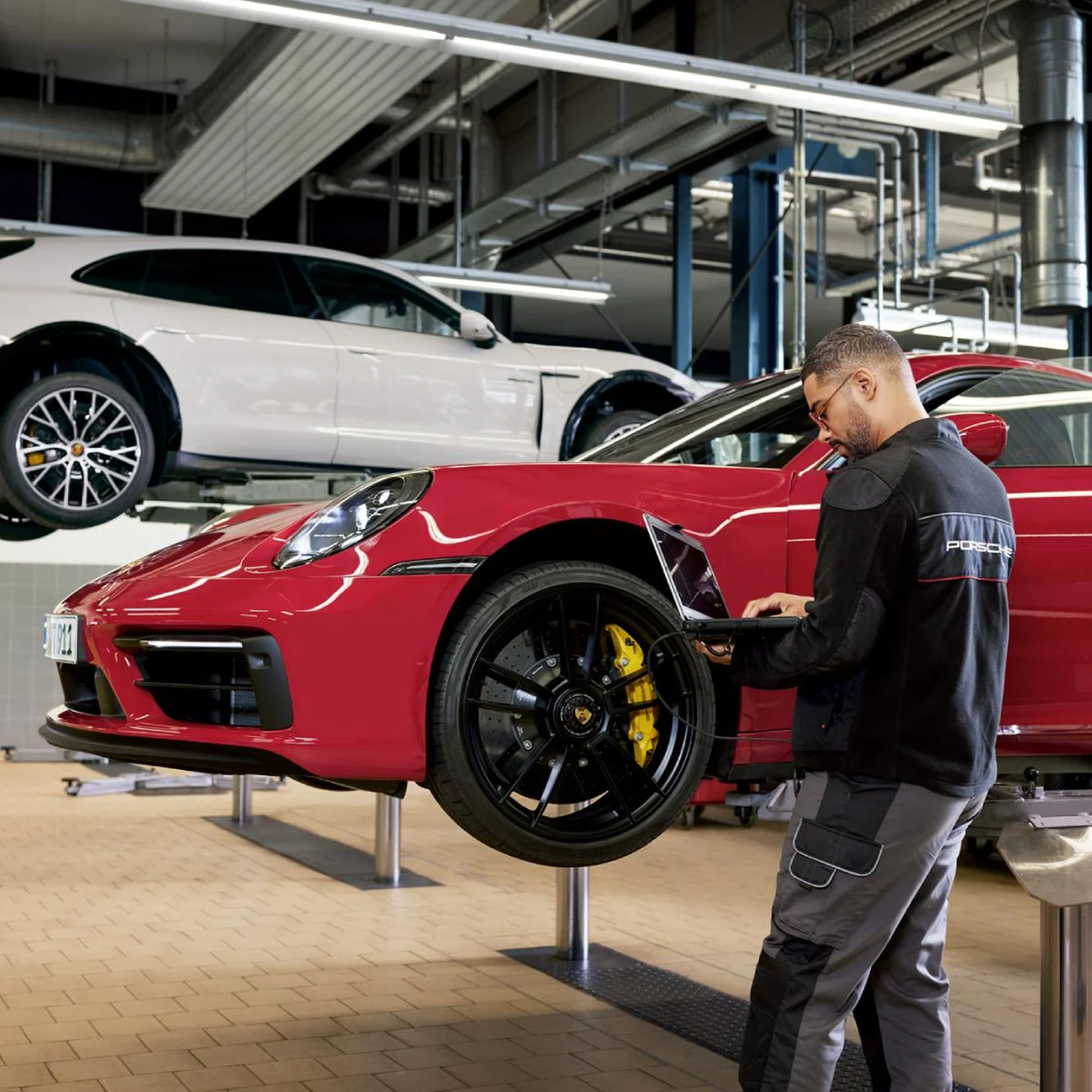 A mecanic repairing a Porsche car.