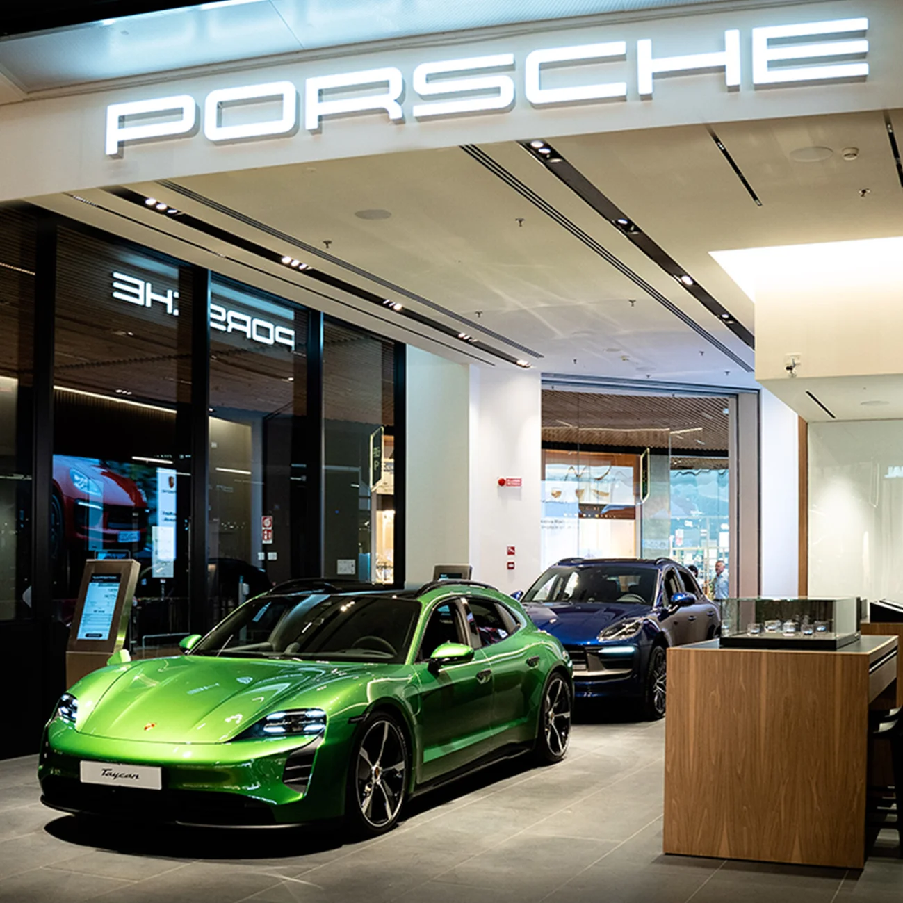 Un negozio Porsche con due veicoli all'interno in esposizione.