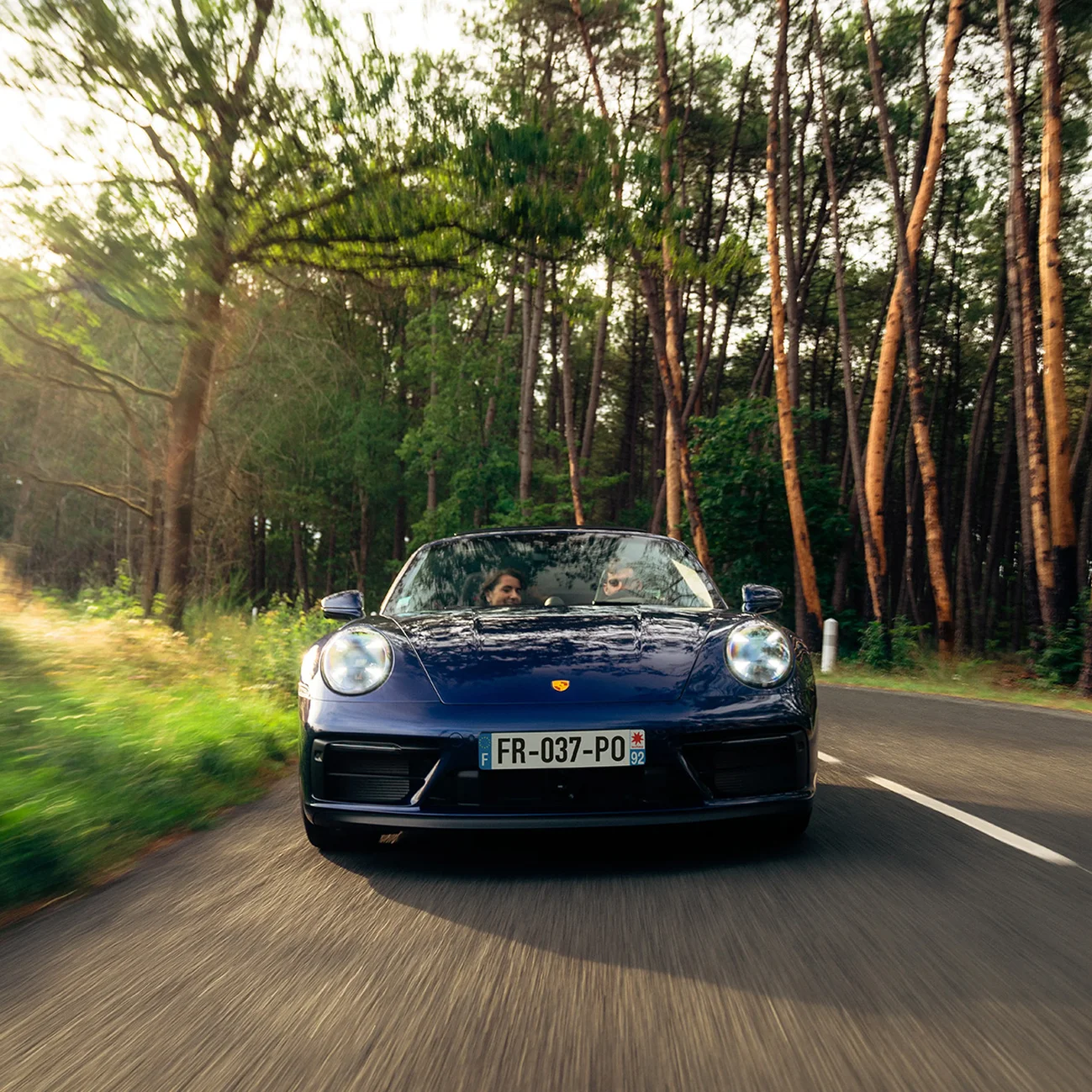 Un homme et une femme dans Porsche 911 Targa 4 GTS louée avec le service Porsche Drive